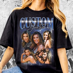 K&ouml;nnte beinhalten: Schwarzes T-Shirt mit einem individuellen Design mit dem Wort "CUSTOM" in Blau und Wei&szlig;, darunter die Worte "Your Text". Das Design enth&auml;lt mehrere Bilder einer Frau. Das Shirt hat einen Vintage-Stil.