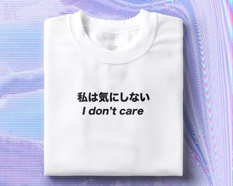 Puede incluir: Camiseta blanca con texto negro que dice "私は気にしない I don't care".