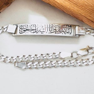 Peut inclure: Un bracelet en argent avec une chaîne à maillons et un pendentif rectangulaire orné de calligraphie arabe.