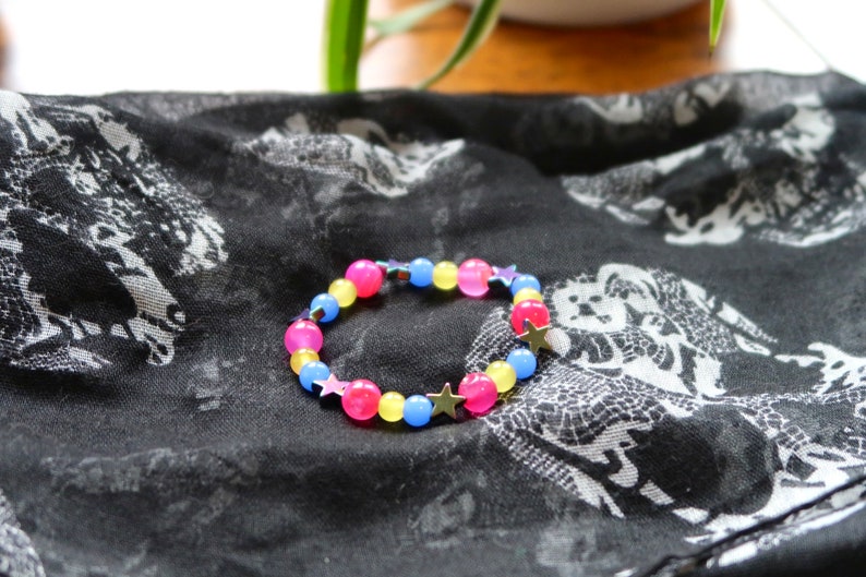 Pansexual/Panromantic pride flag star beaded gemstone bracelet. The beads are the pan flag colors (pink, yellow, cyan) and holographic stars.