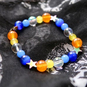 May include: A colorful beaded bracelet with blue, orange, yellow, and clear beads. The bracelet has silver star charms.