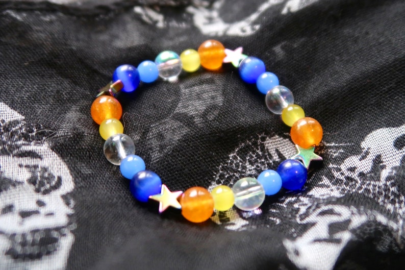 Aroace pride flag star beaded gemstone bracelet. The beads are the aroace flag colors (orange, yellow, white, blues) and holographic stars.