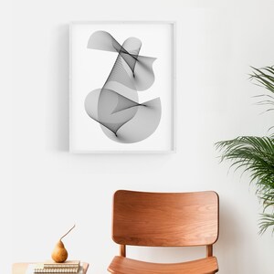 May include: A black and white abstract line art print in a white frame. The print features a series of curved lines that create a swirling, organic shape.