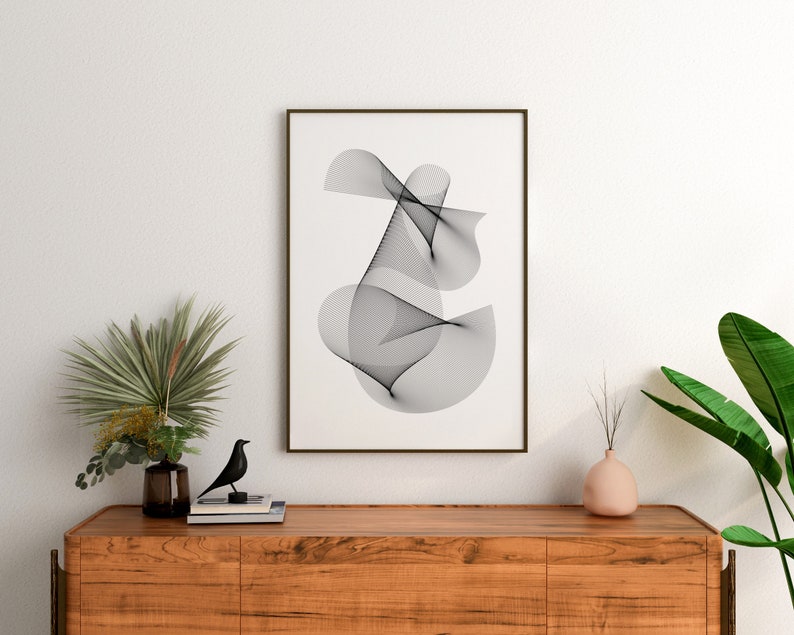May include: A black and white abstract line art print in a brown frame hanging on a white wall above a wooden dresser with a black bird figurine, a vase with green leaves, and a pink vase with dried branches.