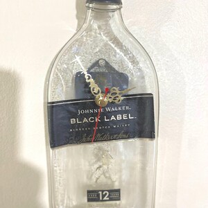 Reloj de pared con tapa y botella aplastada de whisky Johnnie Walker de etiqueta negra