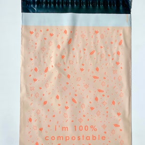 May include: A brown mailing envelope with a black border and a white stripe. The envelope has a repeating pattern of orange leaves and flowers. The text "i'm 100% compostable" is printed in orange at the bottom.