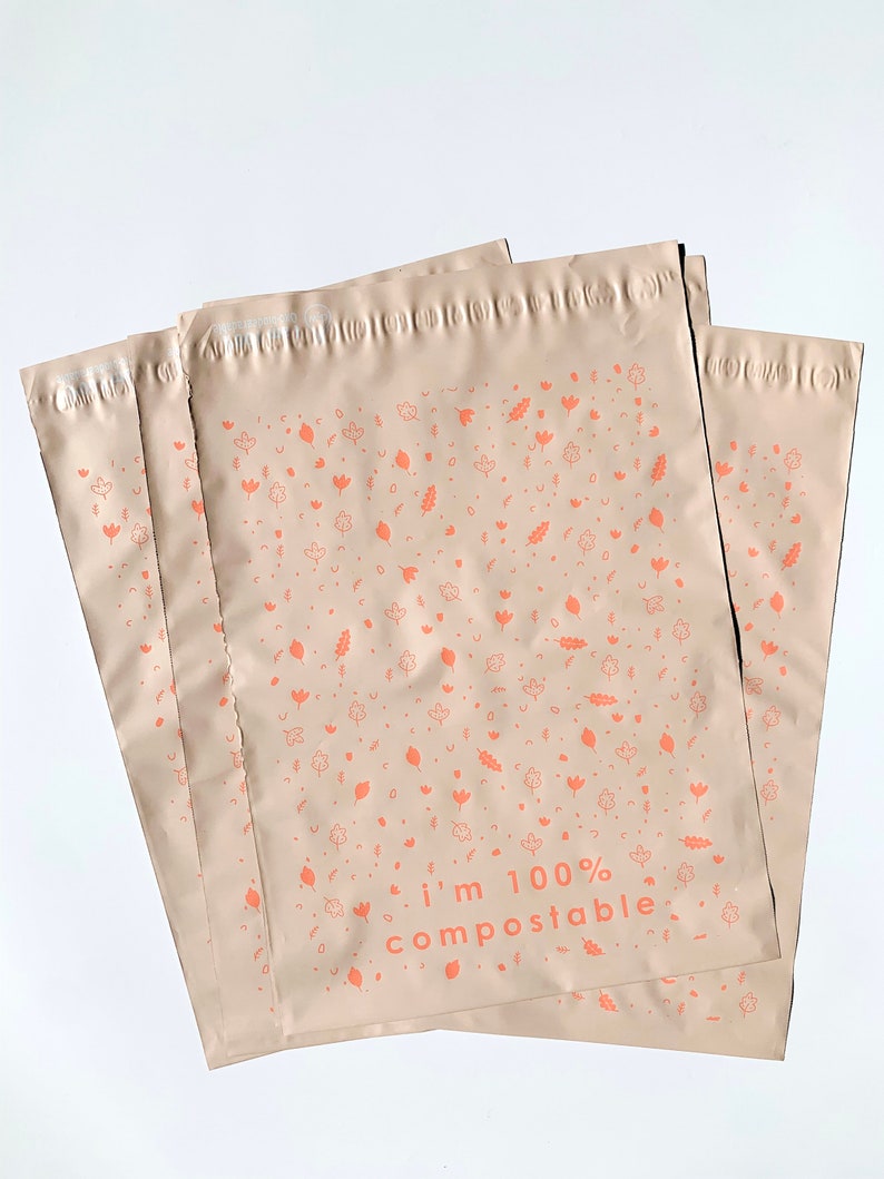 May include: Stack of four brown compostable mailing envelopes with a repeating pattern of leaves and flowers in a light orange color. The text "i'm 100% compostable" is printed in orange on the front of the envelope.