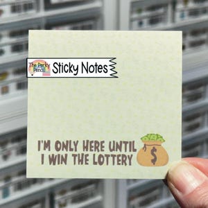 May include: A square sticky note with the text "I'M ONLY HERE UNTIL I WIN THE LOTTERY" and a money bag graphic. The note has a light green background with small yellow dots. The top of the note reads "Sticky Notes".