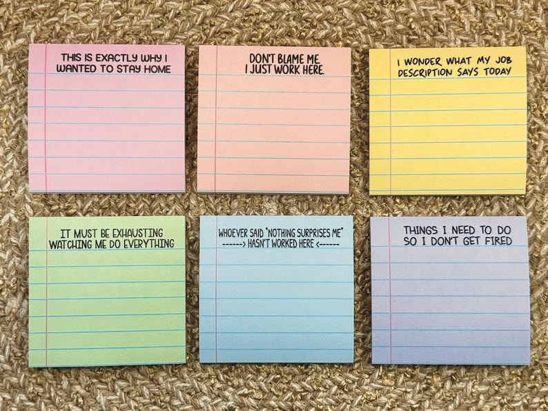May include: Six colourful sticky note pads with humorous text. The pads are pink, peach, yellow, green, blue, and lavender. Each pad has lines and a different phrase, such as "This is exactly why I wanted to stay home."