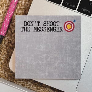 May include: A gray sticky note with the text "DON'T SHOOT THE MESSENGER" in black font. A red target with a yellow bullseye and a blue arrow is in the upper right corner.