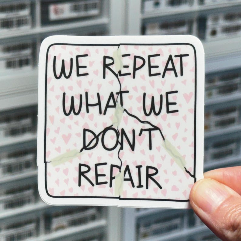 May include: A white sticker with a pink background and a cracked design. The sticker has the text "We repeat what we don't repair" in black.