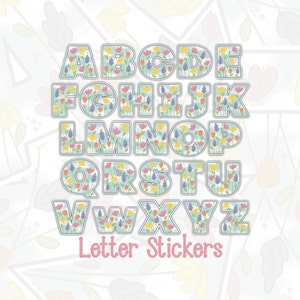 May include: A set of alphabet letter stickers with a floral design. Each letter is outlined in gray and filled with a light blue background with colorful flowers. The letters are arranged in two rows. The text "Letter Stickers" is below the letters.