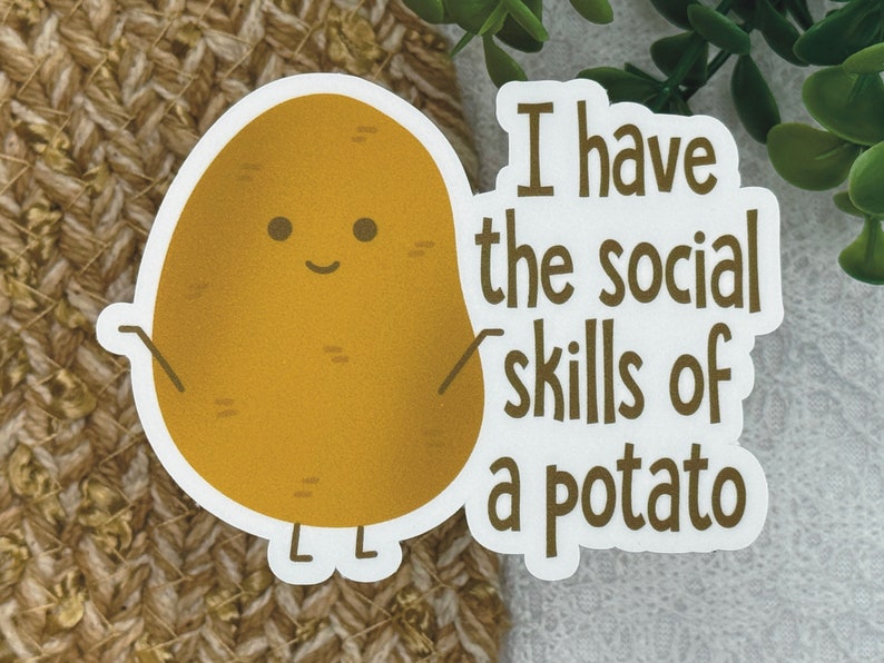 May include: A white sticker with a brown potato cartoon character with a smiling face and the text "I have the social skills of a potato".