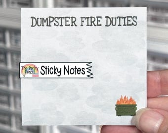 May include: A square sticky note with a light grey background featuring faint cloud patterns. The text DUMPSTER FIRE DUTIES is printed in black at the top. A small illustration of a green dumpster with orange flames is located at the bottom right.