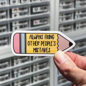 May include: A yellow pencil sticker with a pink eraser and the text "Always fixing other people's mistakes".