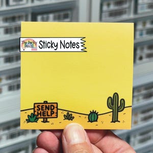 May include: A square yellow sticky note featuring a desert landscape illustration at the bottom with a sign that reads SEND HELP, a small green cactus, and a larger saguaro cactus. A logo in the top left corner displays The Perky Pencil Sticky Notes.