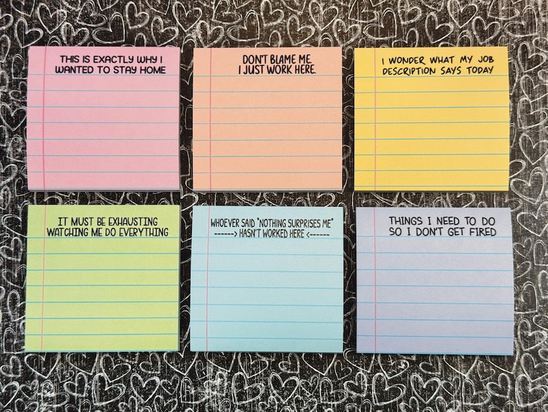 May include: Six colourful sticky notes with humorous phrases in black text. The notes are pink, peach, yellow, green, blue, and lavender. The background is a black surface with white heart doodles.