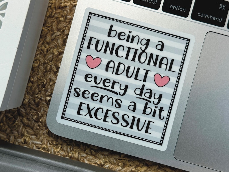 May include: A square sticker with a light gray and white horizontal striped background. The text reads: being a FUNCTIONAL ADULT every day seems a bit EXCESSIVE. Two small pink hearts are placed on either side of the word ADULT.