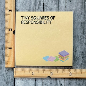 Peut inclure: Un bloc-notes carr&eacute; jaune clair avec le texte "TINY SQUARES OF RESPONSIBILITY" en noir. Une pile de carr&eacute;s color&eacute;s se trouve dans le coin inf&eacute;rieur droit. Une r&egrave;gle en bois est sur le c&ocirc;t&eacute; gauche et en bas.