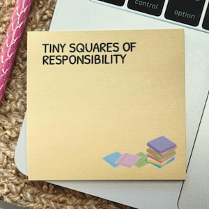 Peut inclure: Un bloc-notes dor&eacute; avec le texte "TINY SQUARES OF RESPONSIBILITY" en noir. La note comporte une pile de carr&eacute;s color&eacute;s en bas &agrave; droite. Un stylo rose avec une pointe argent&eacute;e est &agrave; gauche.