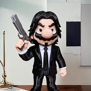 May include: A figurine of a character in a black suit, black tie, and black hair, holding a silver handgun. The character has a large mustache and a large nose. The figurine is standing on a wooden surface.