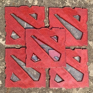 Puede incluir: Cinco posavasos cuadrados rojos con acabado brillante. Cada posavasos presenta un diseño estilizado en forma de 'N' diagonal con interior gris. Los posavasos están dispuestos en un patrón ligeramente superpuesto sobre una superficie texturizada.
