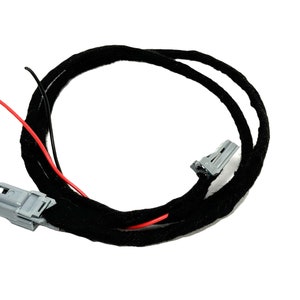 May include: A black wire harness with two gray connectors and red and black wires. The wires are wrapped in black fabric.