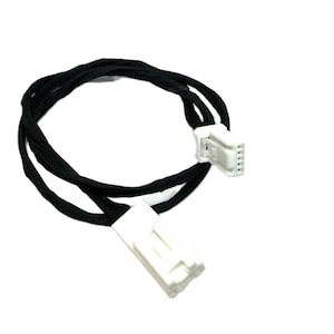 May include: A black electrical cable with two white connectors. The cable is looped and appears to be made of a flexible, fabric-like material. The connectors have multiple pins.