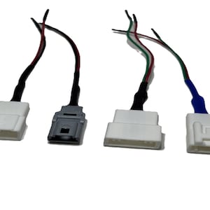 May include: Four electrical connectors with wires. Two connectors are gray and white, one is gray and black, and one is gray and blue.