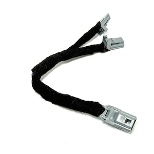 May include: A black wire with two gray connectors on each end. The wire is covered in black fabric.
