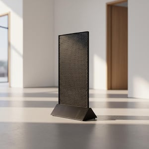May include: A black metal room divider with a perforated pattern. The divider stands on a rectangular base. The background shows a bright, minimalist interior with natural light.