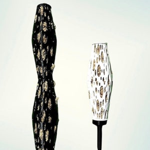 Pode incluir: Dois objetos decorativos alongados. Um é preto com detalhes dourados, o outro é branco com detalhes dourados. O texto "STL FILE" está em vermelho no topo da imagem. Os objetos têm um design texturizado único.