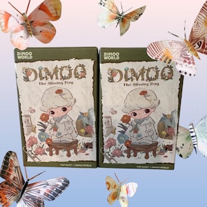 May include: Two DIMOO World collectible boxes, featuring a cartoon character holding a rose, with the text "The Missing Day." The boxes are surrounded by colorful butterflies. The boxes are green and white.