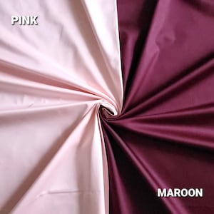 May include: A fabric sample showing two colours, pink and maroon. The pink fabric is on the left, and the maroon fabric is on the right. The word "PINK" is in white text on the upper left, and "MAROON" is in white text on the lower right.