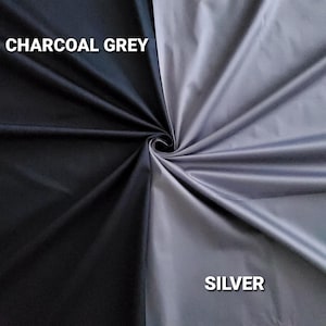 May include: A fabric sample divided diagonally, with charcoal grey on one side and silver on the other. The words "CHARCOAL GREY" and "SILVER" are printed in white, indicating the fabric colours.