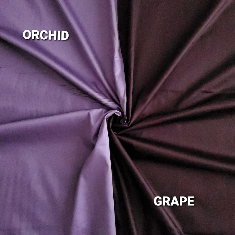 May include: A fabric swatch split into two colours: orchid and grape. Orchid is a light purple, and grape is a deep, dark purple. The fabric is folded in the centre, creating a swirl. The words "ORCHID" and "GRAPE" are printed on the fabric.