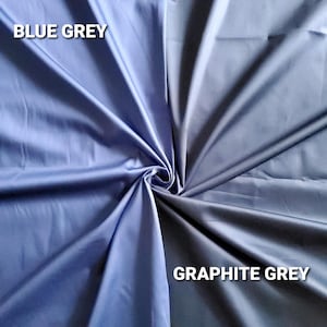 May include: A close-up of two fabric swatches, one in blue-grey and the other in graphite grey. The fabric is folded and draped, with the text "BLUE GREY" and "GRAPHITE GREY" in white.