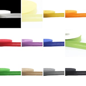 Könnte beinhalten: Eine Auswahl an Schrägband in verschiedenen Farben, darunter Weiß, Gelb, Orange, Rot, Lila, Blau, Grün, Braun, Grau und Schwarz. Das Schrägband ist in Rollen dargestellt.