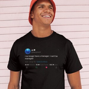 May include: A black t-shirt featuring a tweet from Kanye West that reads "I no longer have a manager. I can't be managed." The tweet has 49.1K retweets, 22.6K quote tweets, and 222.7K likes.