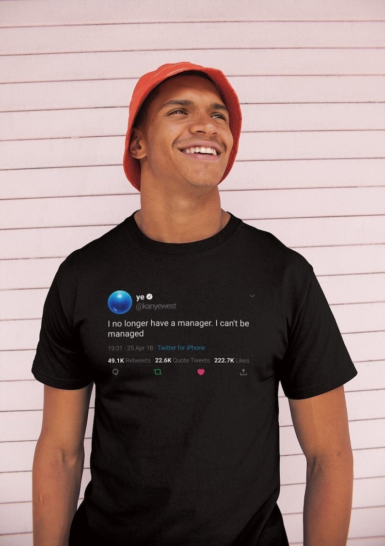 May include: A black t-shirt featuring a tweet from Kanye West that reads "I no longer have a manager. I can't be managed." The tweet has 49.1K retweets, 22.6K quote tweets, and 222.7K likes.