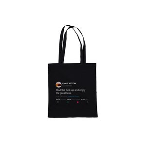 May include: Black tote bag with a white graphic of a tweet from Kanye West that reads "Shut the fuck up and enjoy the greatness." The tweet has 26.7K retweets, 19.7K quote tweets, and 93.1K likes.