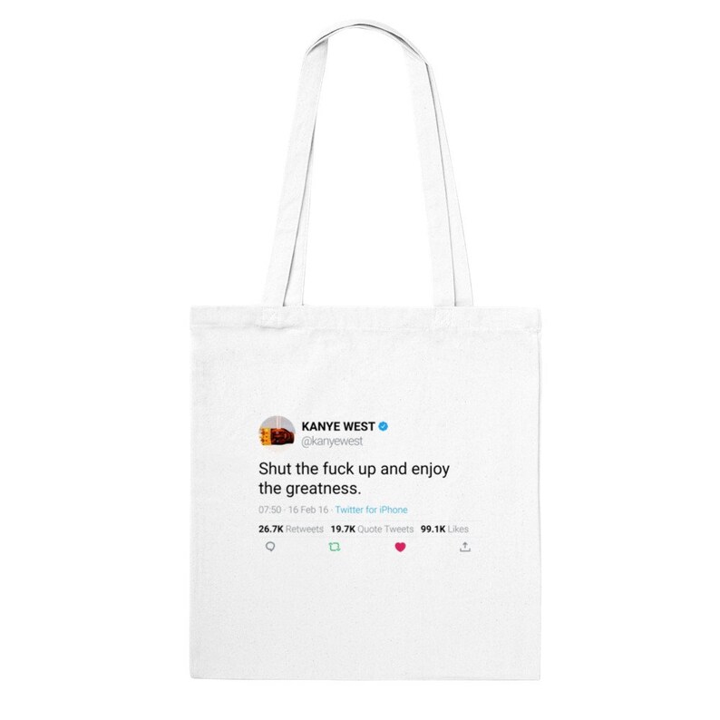May include: White tote bag with a printed image of a tweet from Kanye West. The tweet reads "Shut the fuck up and enjoy the greatness." The tweet has 26.7K retweets, 19.7K quote tweets, and 99.1K likes.