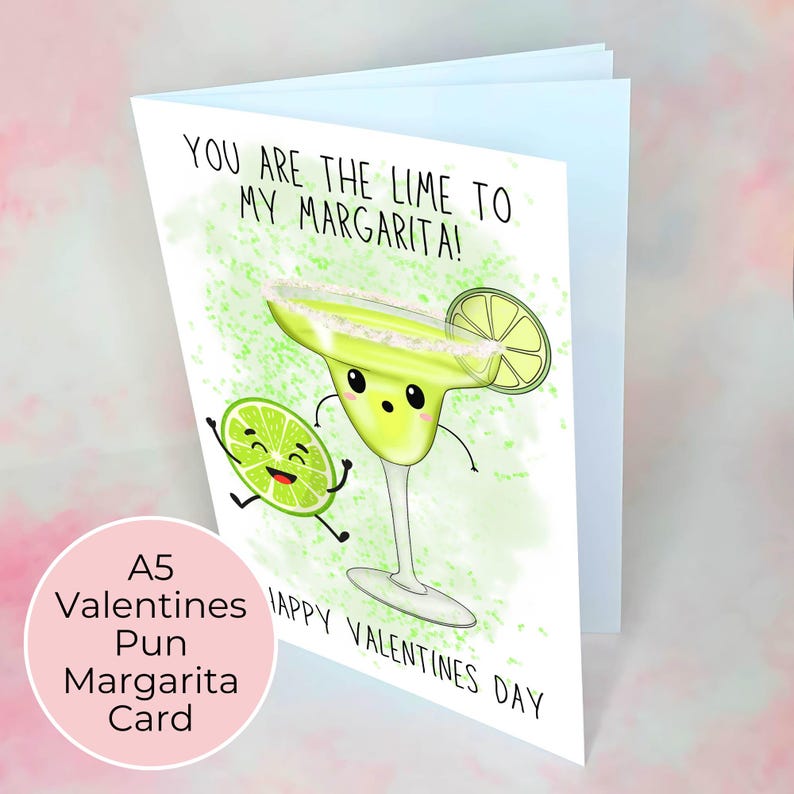 Puede incluir: Una tarjeta de San Valent&iacute;n con un dise&ntilde;o de dibujos animados de un vaso de margarita y una lima. La tarjeta dice "YOU ARE THE LIME TO MY MARGARITA!" y "HAPPY VALENTINES DAY". Un c&iacute;rculo rosa en la parte inferior izquierda dice "A5 Valentines Pun Margarita Card".