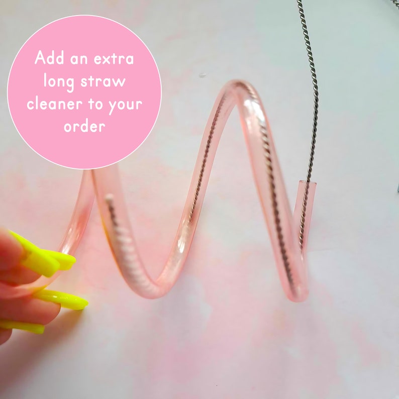 May include: A pink straw cleaner with a silver wire inside. The straw cleaner is coiled and the wire is sticking out of the end. The text "Add an extra long straw cleaner to your order" is written in white on a pink circle.