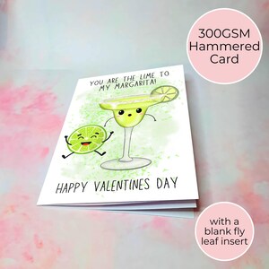 Puede incluir: Una tarjeta de San Valent&iacute;n con un dise&ntilde;o de dibujos animados de margarita y lima. La tarjeta dice "YOU ARE THE LIME TO MY MARGARITA!" y "HAPPY VALENTINES DAY". La tarjeta est&aacute; hecha de cartulina martillada de 300 g/m&sup2;.