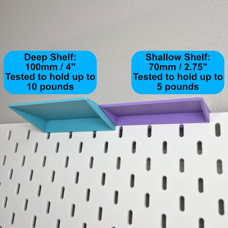 Puede incluir: Un tablero perforado blanco con dos estantes adjuntos. El estante profundo azul mide 100 mm / 4 pulgadas y soporta hasta 10 libras. El estante poco profundo morado mide 70 mm / 2.75 pulgadas y soporta hasta 5 libras, seg&uacute;n las etiquetas de texto.