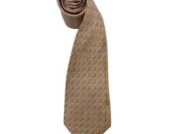 May include: A necktie in a dusty rose pink color featuring a repeating pattern of interlocking gold-toned chain links. The tie is rolled at the top and extends downward into a pointed blade, showcasing a consistent geometric design throughout the fabric.