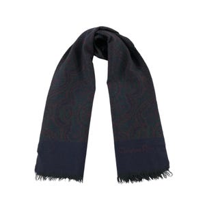 May include: A dark blue paisley patterned scarf with a fringed edge. The scarf has a small "Christian Dior" logo in the bottom right corner.
