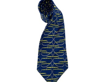 May include: A navy blue tie with a repeating pattern of yellow chains and horizontal bars. The tie is knotted at the top, with the patterned fabric visible. The tie is a classic accessory.