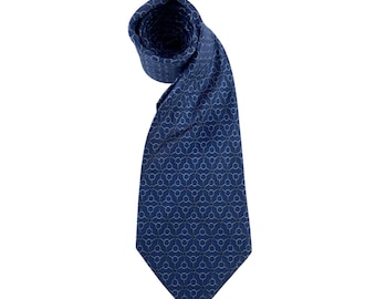 May include: A navy blue tie with a repeating geometric pattern in a lighter shade of blue. The tie is rolled up at the top and hangs down, showcasing the intricate design. The tie is made of a smooth fabric.